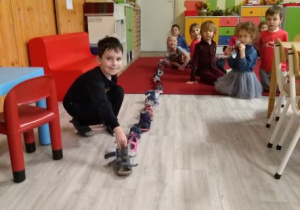 Chłopiec ustawia swojego buta przed butami innych dzieci